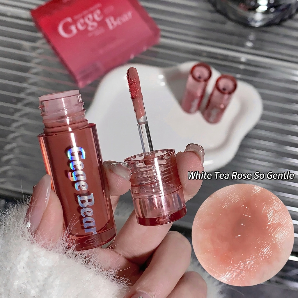 Lip tint with 'Gege Bear' branding held by a hand, with a close-up of the lip color and product packaging in the background.